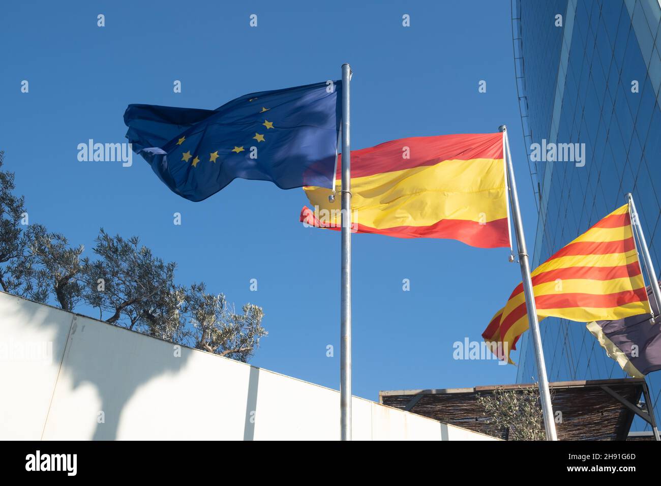 Flaggen der EU, Spaniens und Kataloniens winken am Himmel. Stockfoto