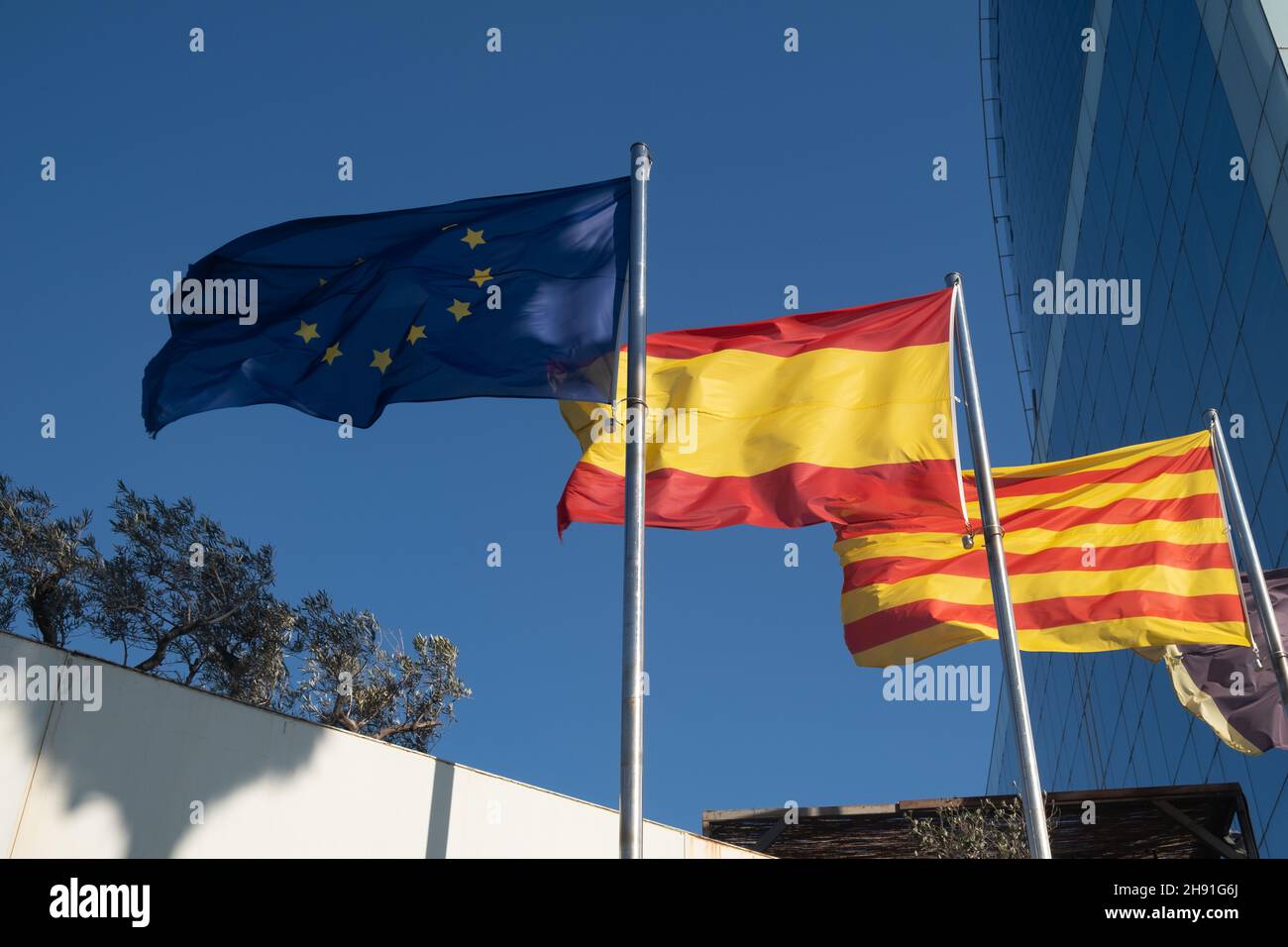 Flaggen der EU, Spaniens und Kataloniens winken am Himmel Stockfoto