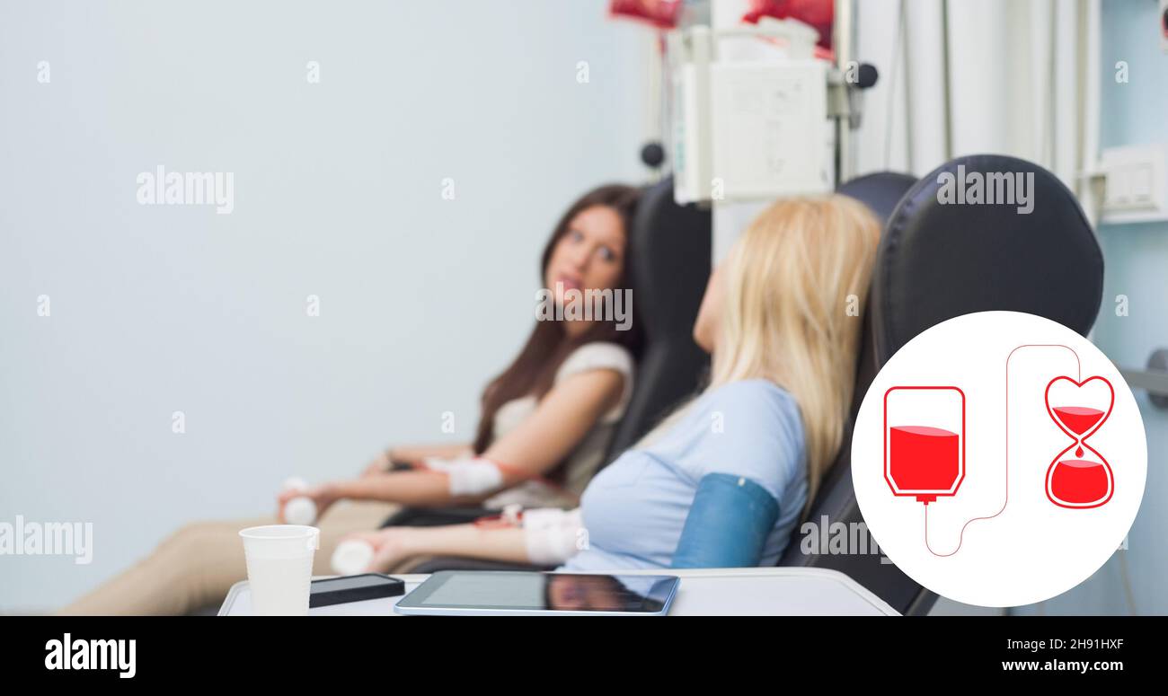 Digitales Komposit aus Blutspendezeichen gegen weibliche Spender, die im Krankenhaus sitzen Stockfoto