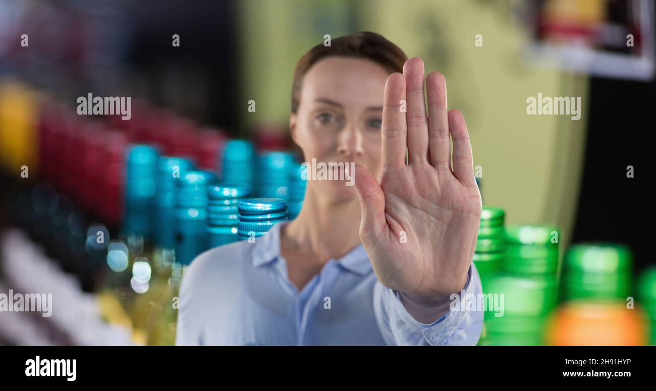 Porträt einer Frau mit Stop-Geste mit der Hand in der Weinhandlung Stockfoto