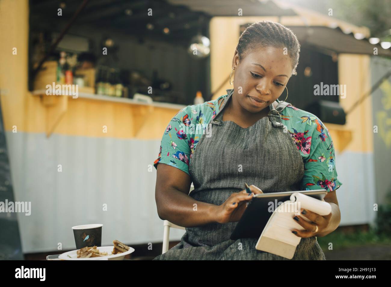 Junge Unternehmerin mit digitalen Tablet gegen Lebensmittel-LKW Stockfoto