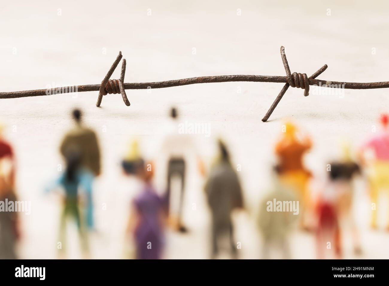Stacheldraht und Plastikspielzeug Männer, illegale Migration Konzept Stockfoto