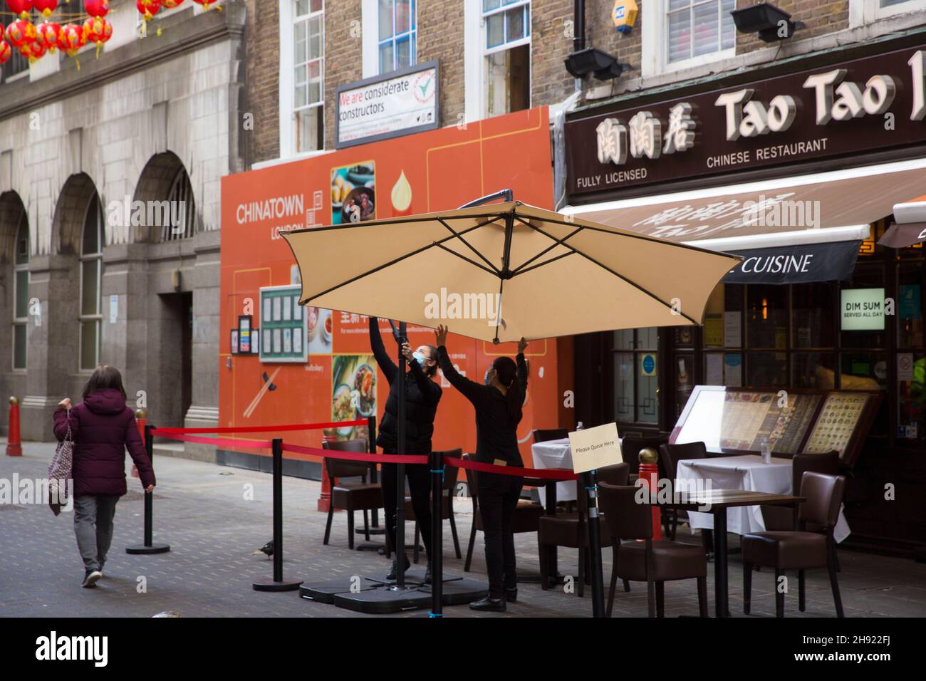 Mitarbeiter bereiten den Außenbereich vor einem Restaurant in Chinatown, im Zentrum von London, vor der nächsten Stufe der Lockerung vor. Stockfoto
