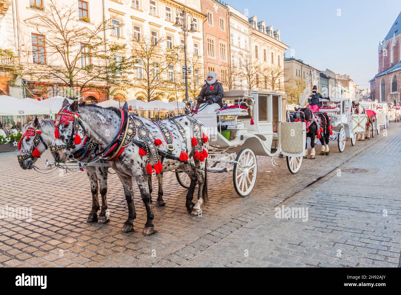 KRAKAU, POLEN - 2. DEZEMBER 2017: Altmodische Pferdekutschen auf dem Rynek Glowny Platz in Krakau, Polen Stockfoto