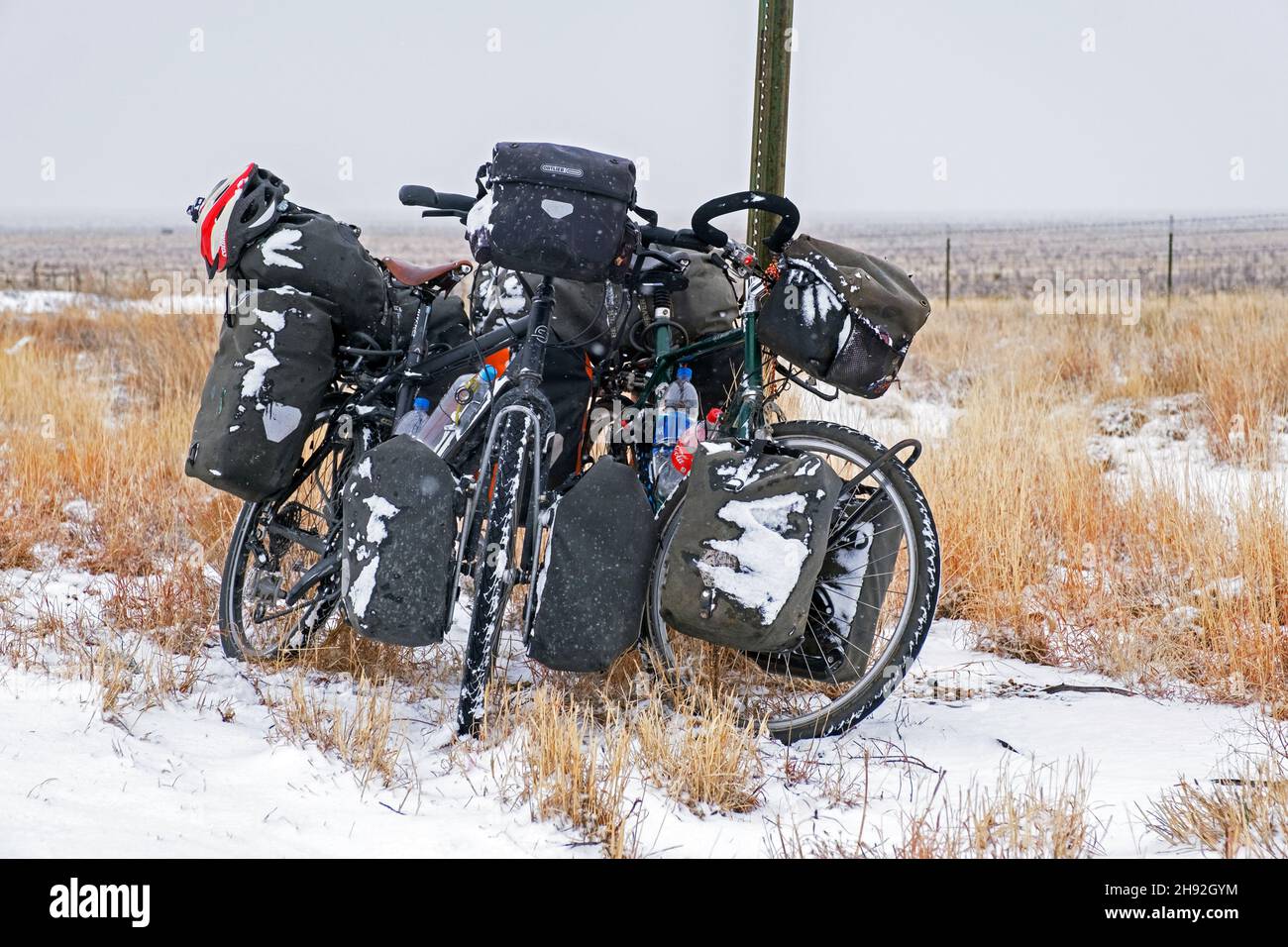 Zwei stark beladene Trekkingräder mit großen Packtaschen im Schnee im Winter, Great Plains, New Mexico, USA / USA Stockfoto