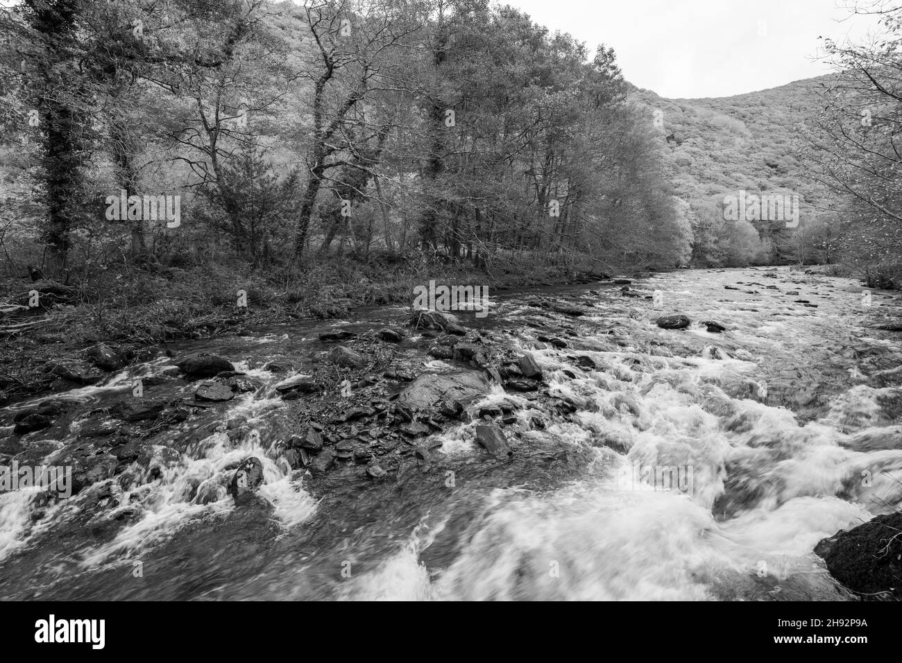 Langzeitbelichtung des East Lyn River, der durch das Doone Valley bei Watersmeet im Exmoor National Park fließt Stockfoto