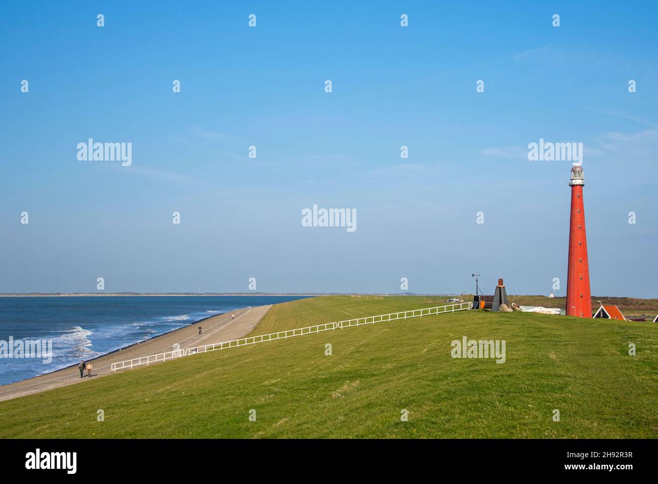Die Menschen verbringen die Zeit auf den Dünen vor dem roten Leuchtturm Stockfoto
