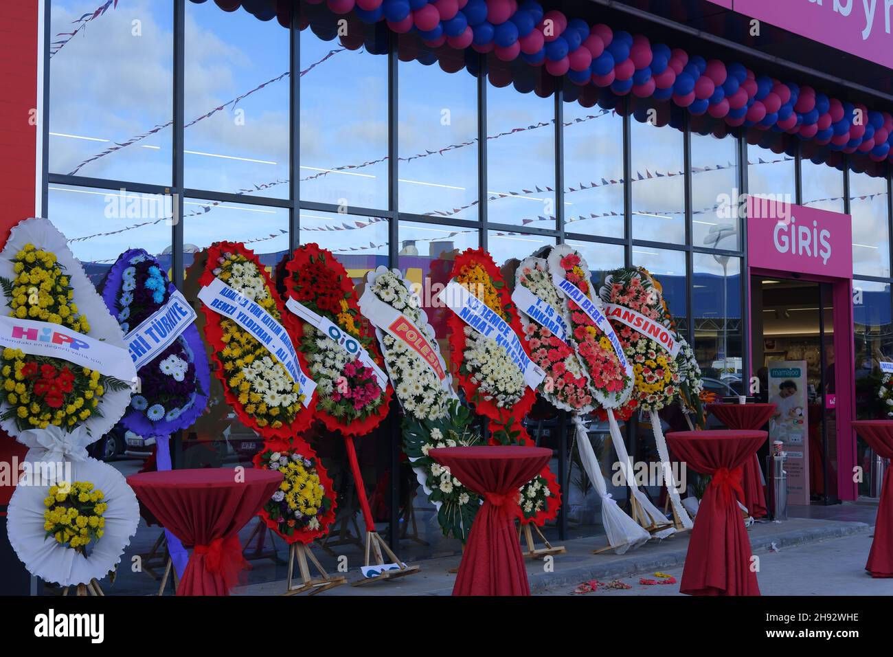 Rot gekleidete kleine Tische und Blumen bei der Eröffnungsparty eines Geschäfts im Freien Stockfoto