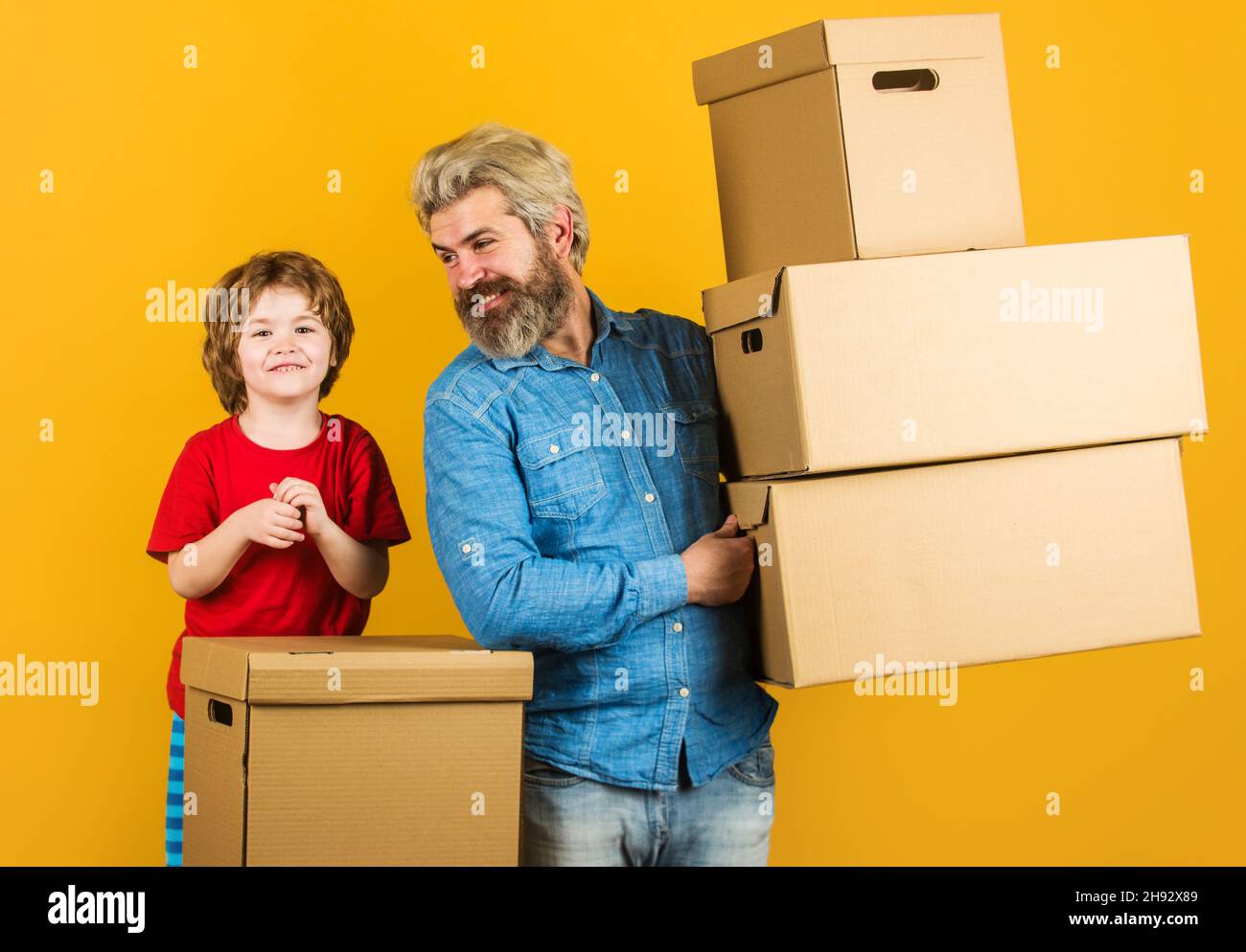 Glücklicher Sohn und Vater mit Pappkartons. Lieferkonzept. Internetkäufe und E-Commerce Stockfoto