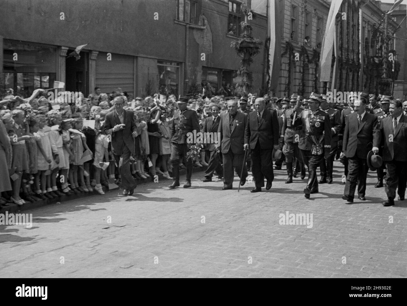 Gniezno, 1947-05-26. Ogólnopolskie obschody Œwiêta Ludowego. NZ. marsza³ek Sejmu W³adys³aw Kowalski (2L z lask¹), marsza³ek Polski Micha³ Rola-¯ymierski (3L z bu³aw¹), prezydent Boles³aw Bierut (4L) udaj¹ siê na trybunê honorow¹ przy ul. Chrobrigo. ps/ms PAP Gniezno, 26. Mai 1947. Nationale Zeremonien anlässlich des Bauernfestes. Im Bild: Sejm-Sprecher Wladyslaw Kowalski (2nd von links mit einem Stock), Polens Marschall Michal Rola-Zymierski (3rd von links mit dem Schlachtfeld), Präsident Boleslaw Bierut (4th von links) auf dem Weg zur Haupttribüne in der Chrobrego Street. ps/ms PAP Stockfoto