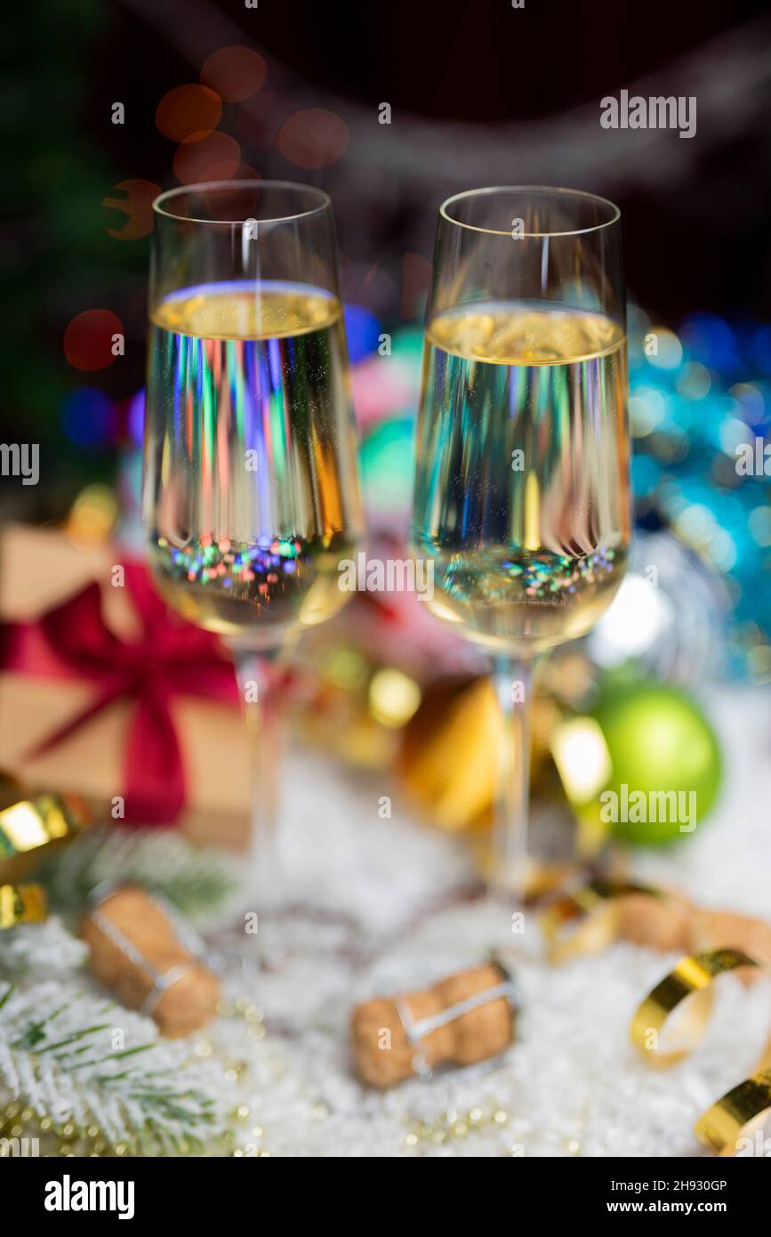 Gläser mit einem Getränk Champagner Wein mit einem Dekor aus Weihnachtsspielzeug auf einem Bokeh Hintergrund für das neue Jahr Stockfoto