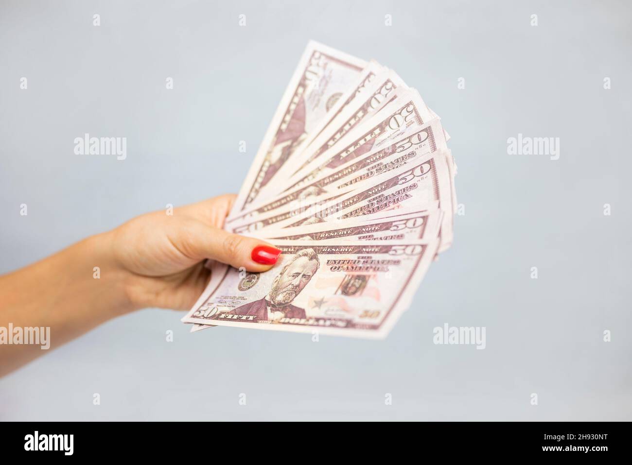 Mädchen hält einen Haufen Geld-Dollar-Scheine, um zu kaufen oder zu bezahlen Stockfoto