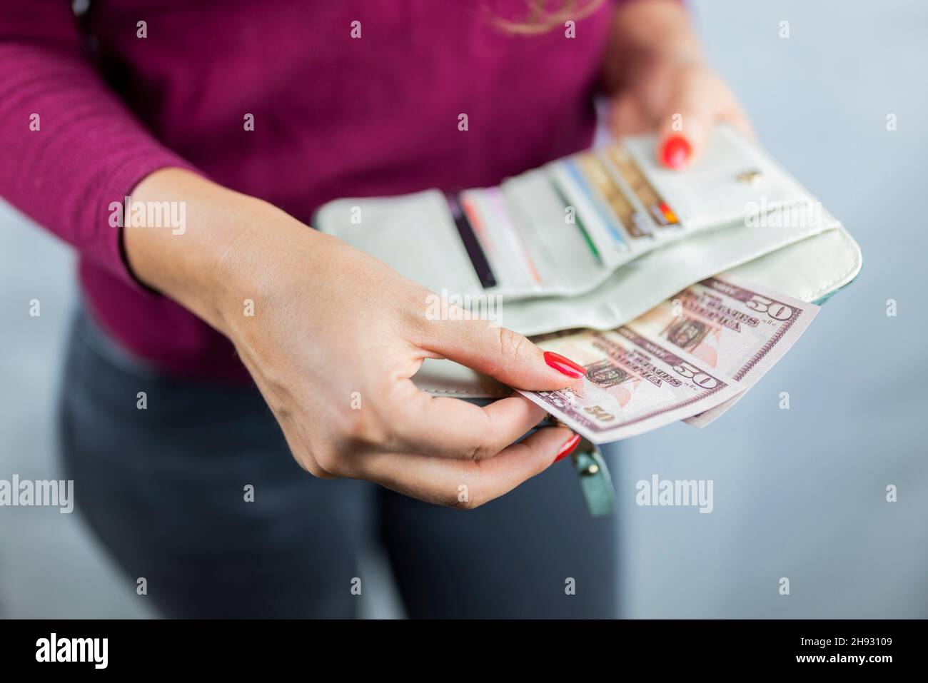 Das Mädchen hält sich in den Händen und zählt die Geldmittel in der Brieftasche Stockfoto