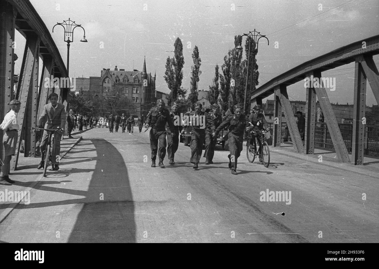 Gniezno, 1947-05-27. Pierwszy ogólnopolski zlot junaków Przysposobienia Rolniczo-Wojskowego (PRW) w GnieŸnie. NZ. Uczestnicy marszu patrolowego na 5 kilometrów na wiadukcie kolejowym. Z ty³u opiekuj¹cy siê zawodnikami oficer Wojska Polskiego na rowerze. ps/ms PAP Gniezno, 27. Mai 1947. Der erste nationale Junglandwirte-Kongress in Gniezno. Im Bild: Die Teilnehmer einer fünf Kilometer langen Straße marschieren auf der Brücke. Im Hintergrund der Offizier der polnischen Armee (auf dem Fahrrad), der sich um die Konkurrenz gefreut hat. ps/ms PAP Stockfoto