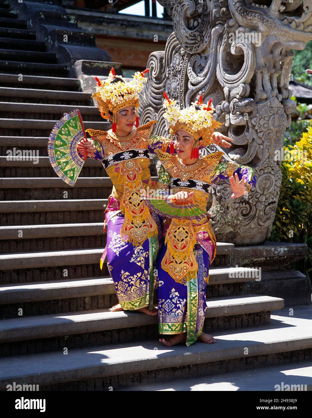 Indonesien. Bali. Zwei junge balinesische Tänzerinnen auf der Tempeltreppe. Stockfoto
