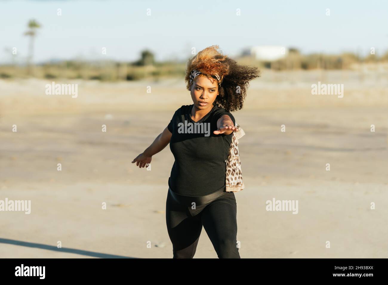 Eine Schwangerin, die Yoga praktiziert, steht am Strand Stockfoto