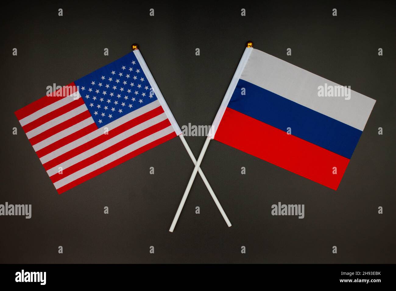 Die USA-Flagge und die russische Flagge kreuzen sich auf schwarzem Hintergrund. USA gegen Russland. Treffen zwischen den Präsidenten der Vereinigten Staaten und Russi Stockfoto