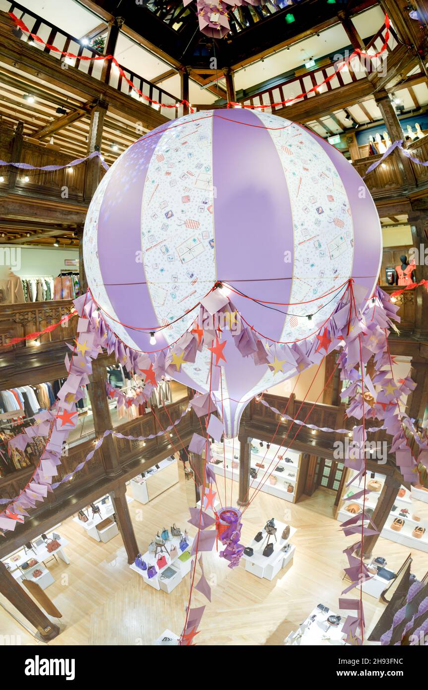 Ansicht von oben nach unten einer riesigen hängenden Heißluftballondekoration im Liberty Store in der Regent Street für Weihnachtseinkäufer, London England, Großbritannien Stockfoto