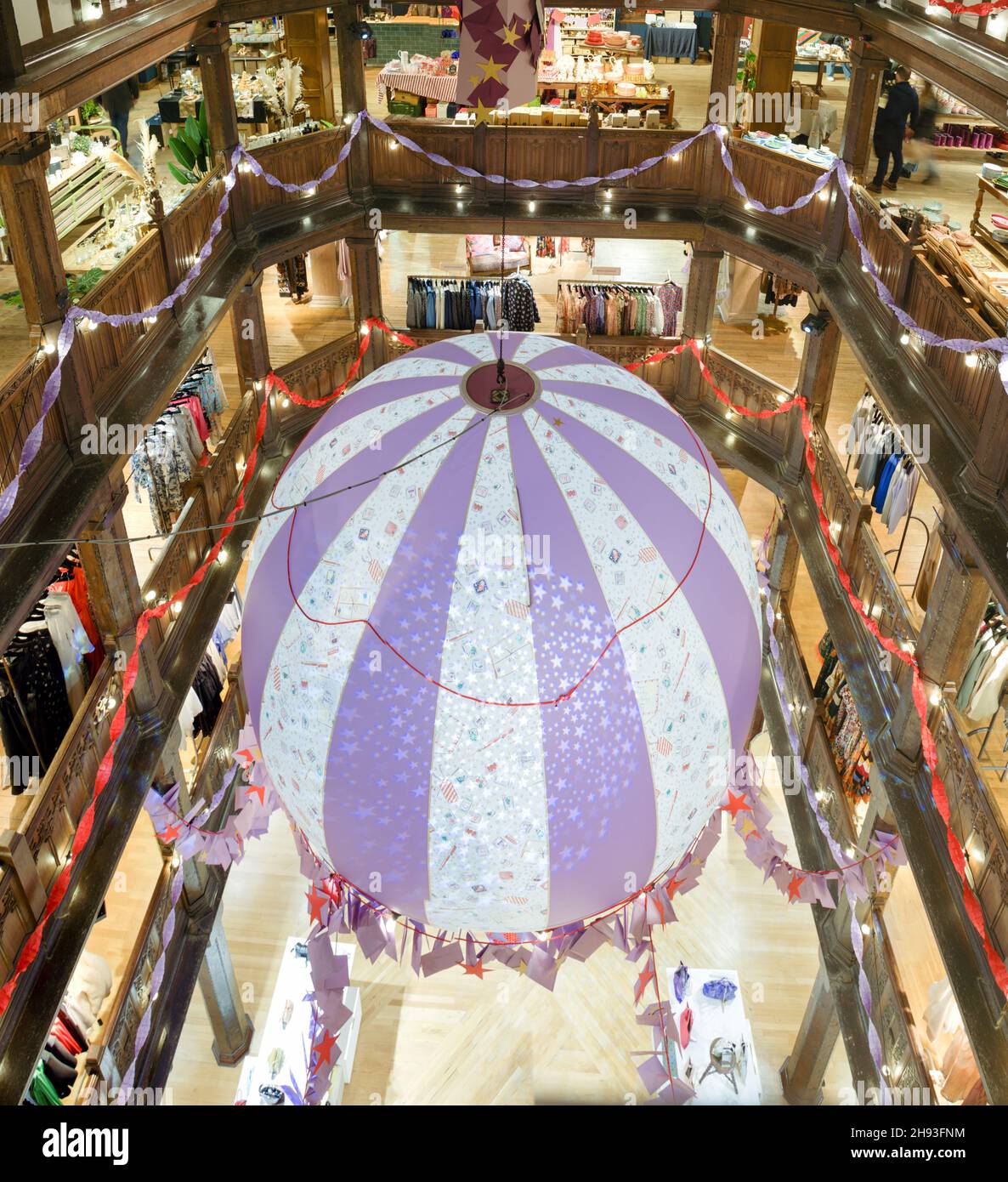 Eine riesige hängende Heißluftballondekoration im Liberty Store in der Regent Street für Weihnachtseinkäufer in London, England Stockfoto