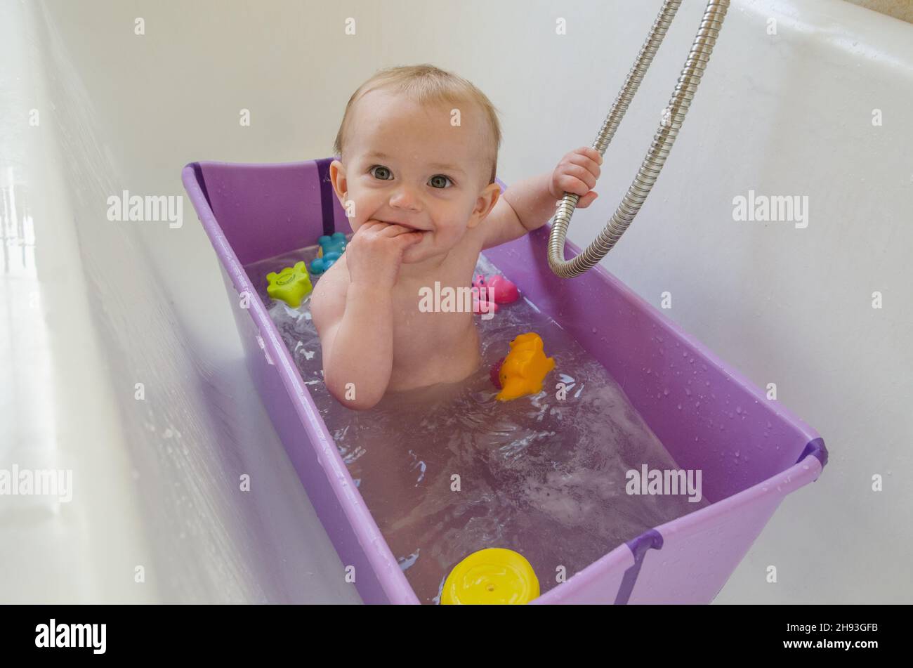 Ein kleines Mädchen (ca. 11 Monate alt) hat ein Bad zu Hause. Stockfoto