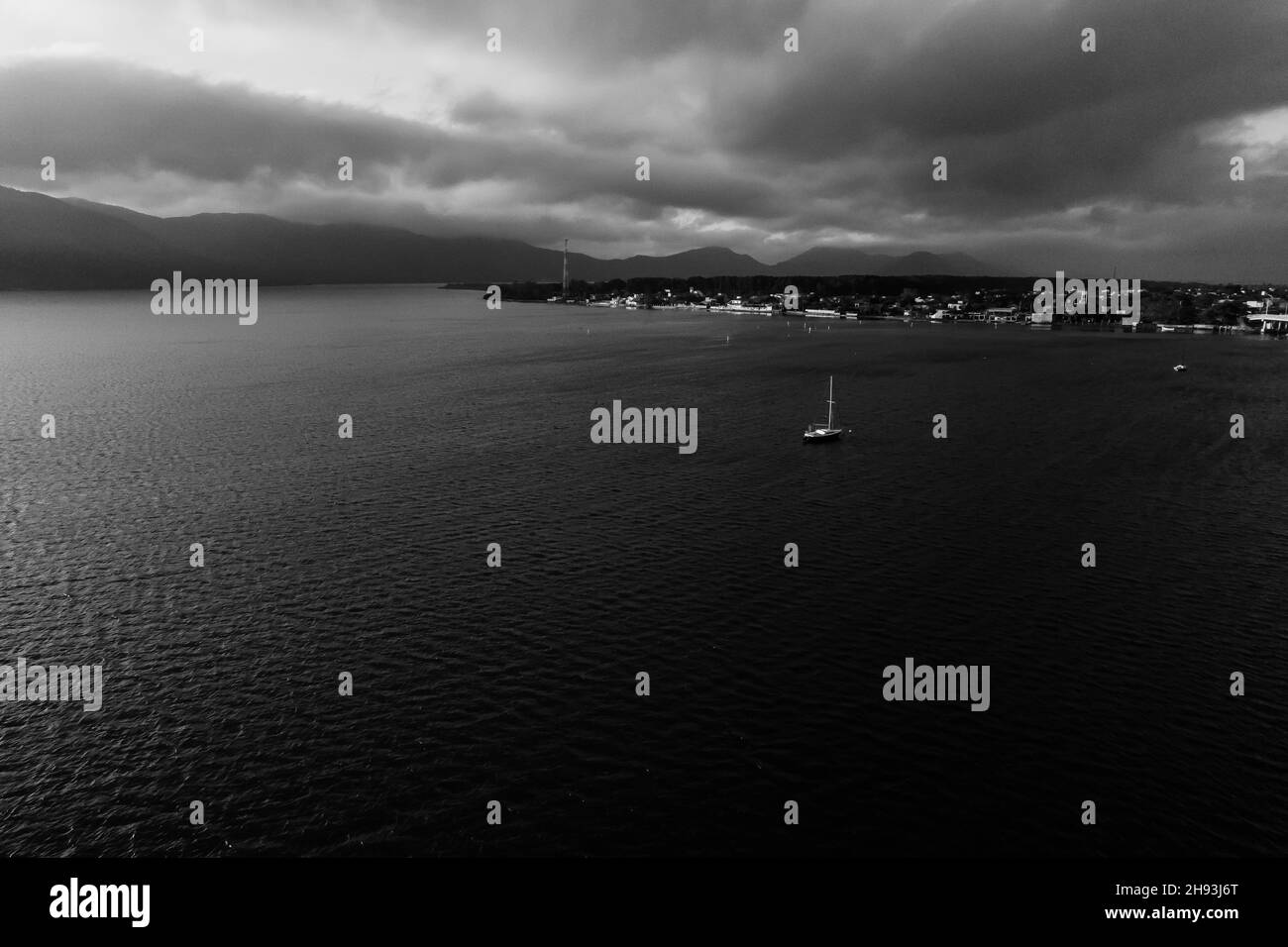 Yacht auf dem Weg an Land. Dramatisches Schwarzweißfoto. Stockfoto