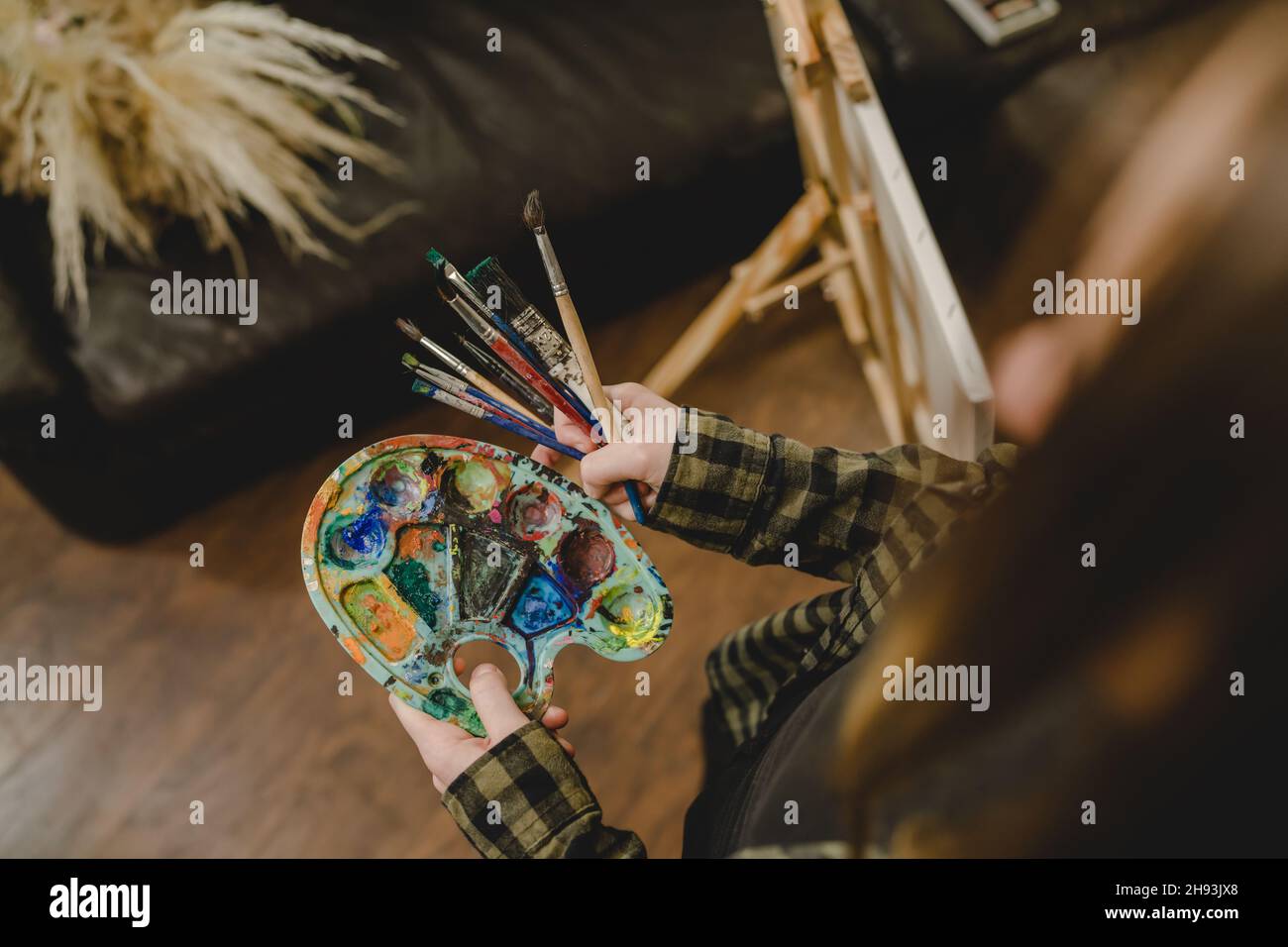 Nahaufnahme der Hände einer unbekannten Malerin, die Farbpalette und Pinsel hält, um die Freizeitgestaltung der Kunst professionell oder ama zu machen Stockfoto