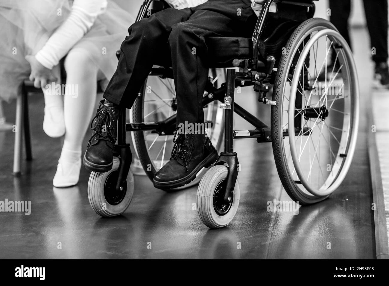 Bild mit geringer Schärfentiefe (selektiver Fokus) und Details eines kranken behinderten Jungen in einem Rollstuhl. Stockfoto