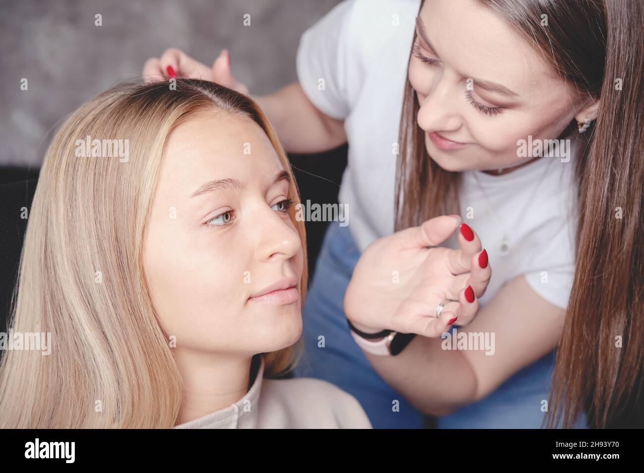Femalevisagiste Anwendung Gesicht kosmetische Grundierung auf die Haut des Modells. Face Foundation für helle helle helle helle Haut. Beauty-und Make-up-Salon. Small Business-Konzept Stockfoto