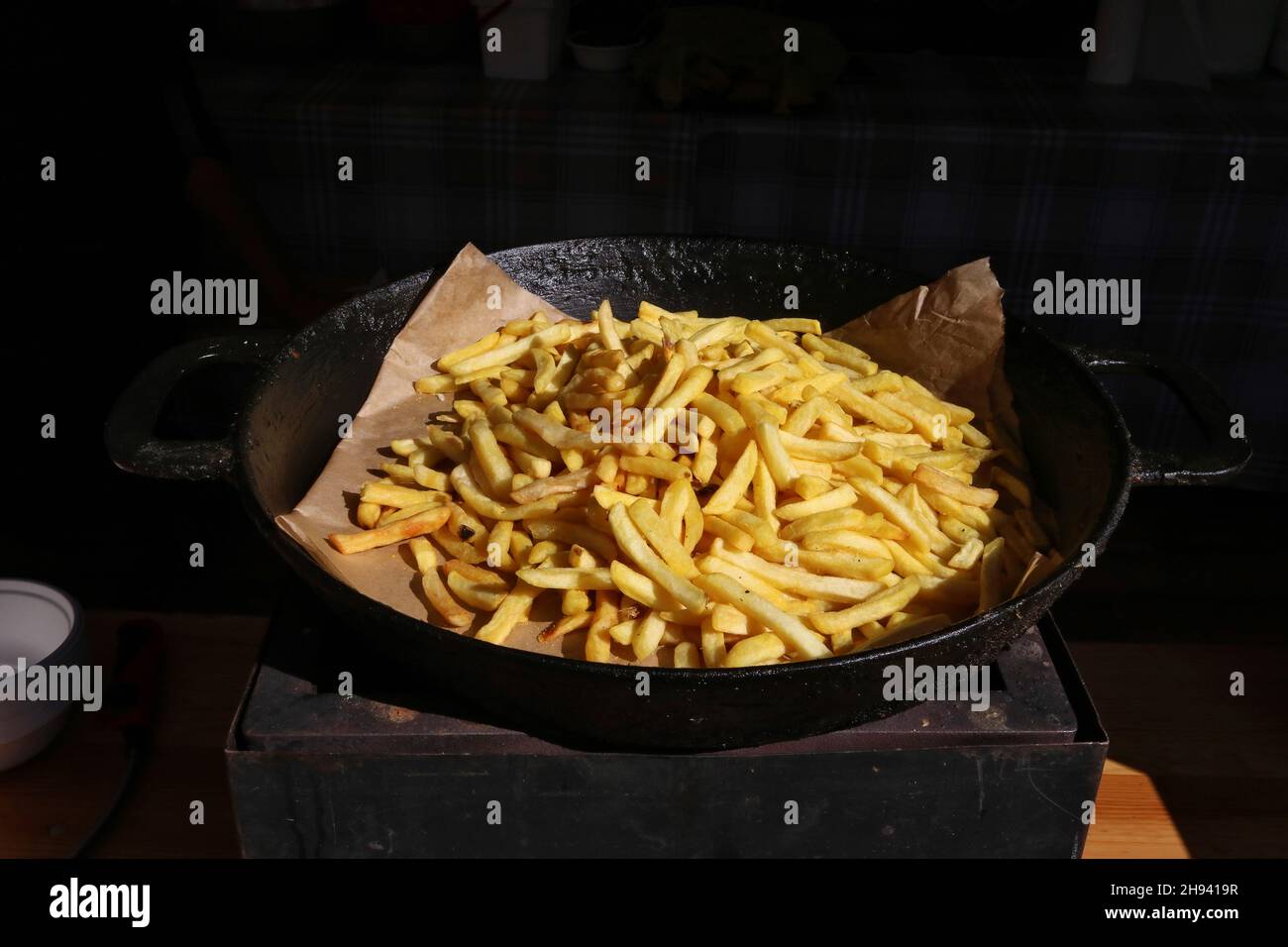 Auf einer schwarzen Bratpfanne liegt ein Haufen gebratener Kartoffeln Stockfoto
