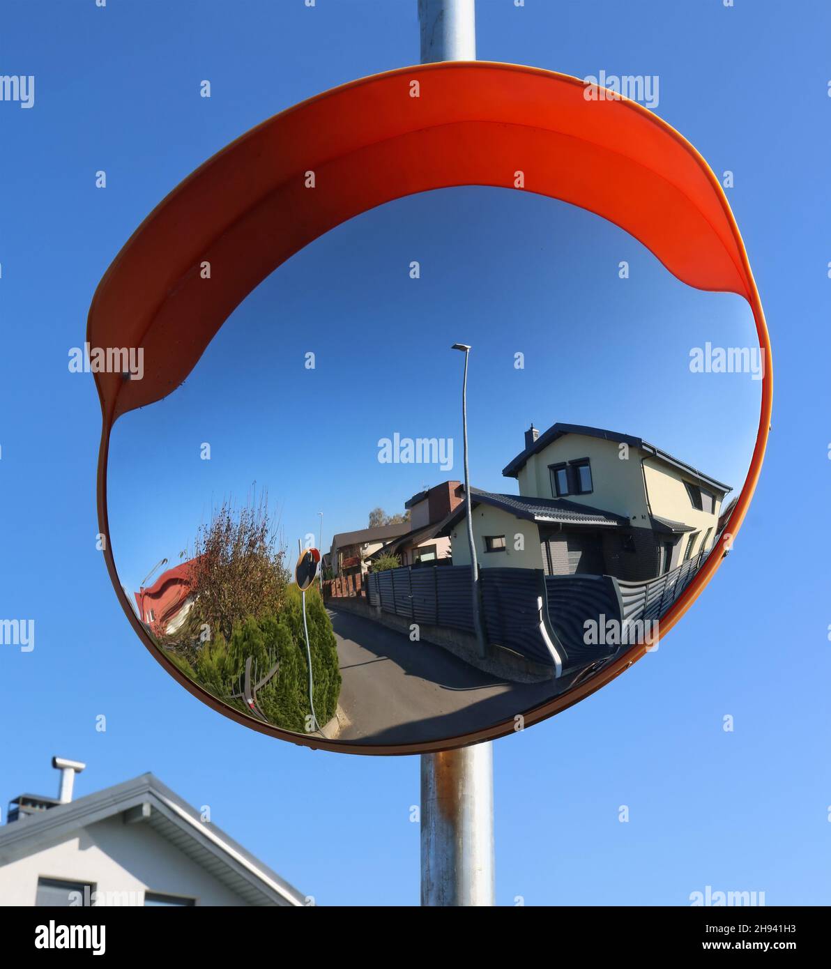 An der Dorfkreuzung ist ein runder konvexer Spiegel installiert Stockfoto