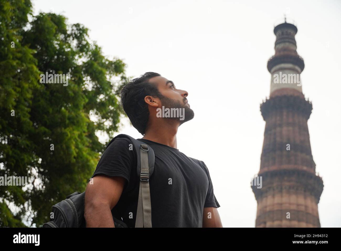 indische junge gutaussehende Mann am historischen Palast qutub minar Reise in indien Bild Stockfoto