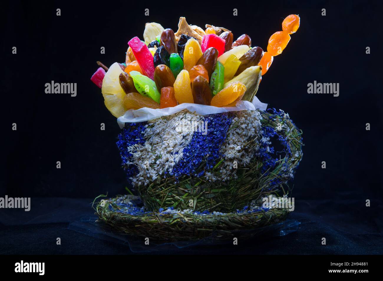 Getrocknete Früchte in einer Tasse gewebter mehrfarbiger Kräuter Stockfoto