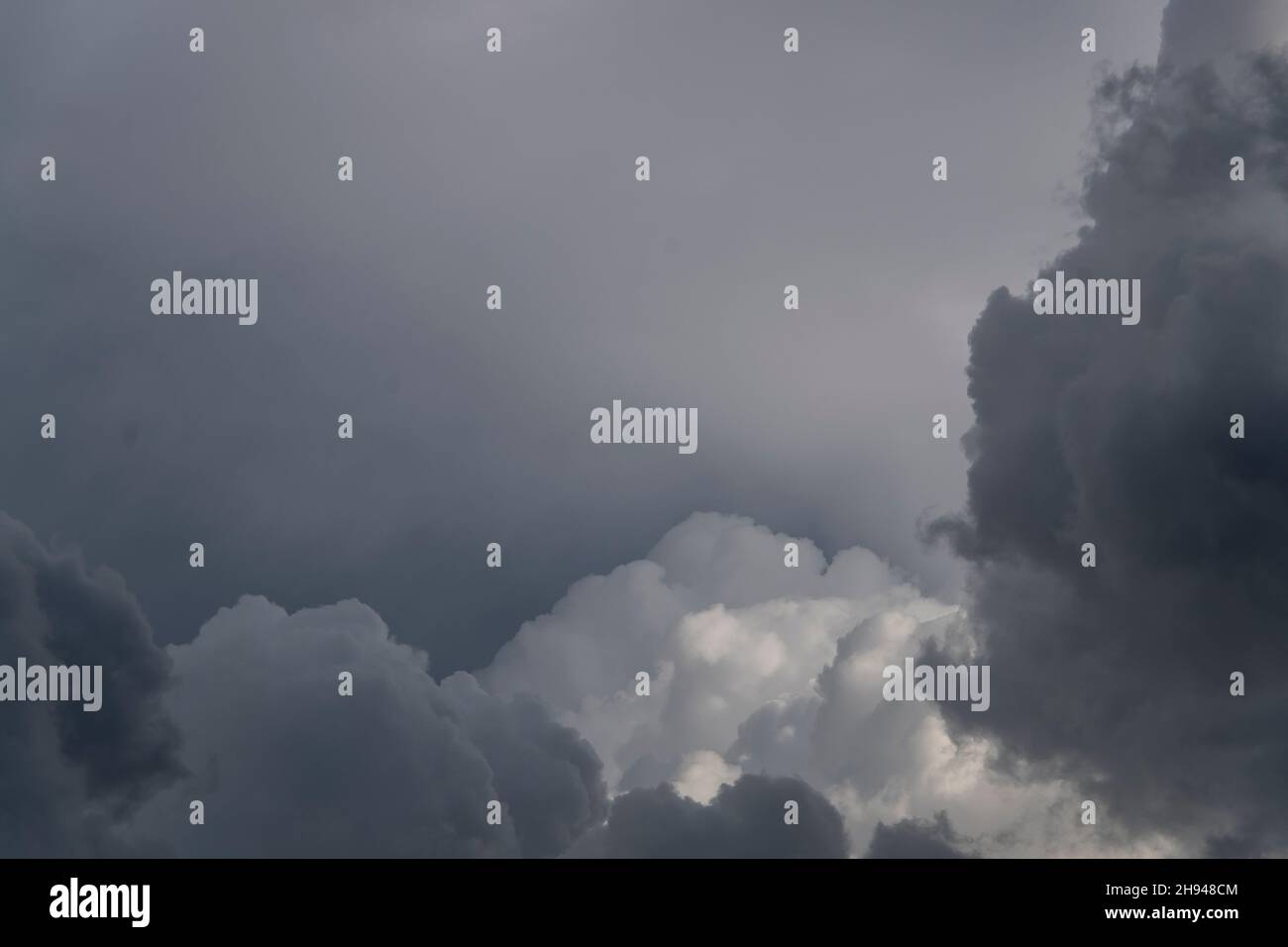 Schattierungen von grauen und weißen Wolken mit einem letzten Hauch von Sonnenschein. Moody, düster, dunkler Himmel. Frühlingsabend, Queensland, Australien. Platz kopieren, Hintergrund. Stockfoto