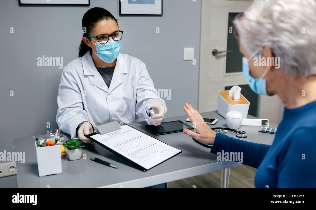 Patient, der den vom Arzt angebotenen Coronavirus-Impfstoff ablehnt Stockfoto