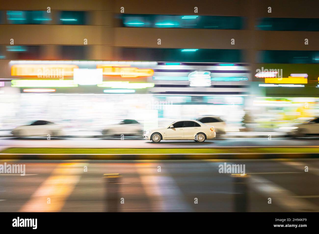Speeding White Car Fast Driving In City Street. Hintergrund Für Bewegungsunschärfe Stockfoto