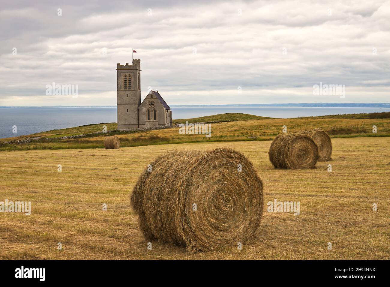 Runde Heuballen nach der Ernte auf dem Feld neben der St. Helen's Church auf Lundy Island, Bristol Channel, Devon, England, Großbritannien Stockfoto