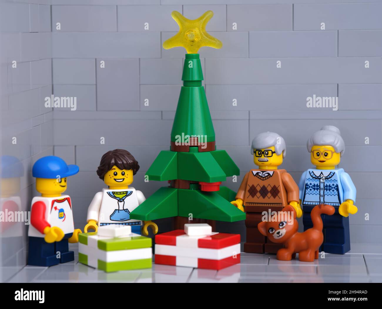 Tambow, Russische Föderation - 01. Dezember 2021 Lego-Großeltern, Enkel und Katzenminifiguren stehen neben einem Weihnachtsbaum mit Geschenken Stockfoto