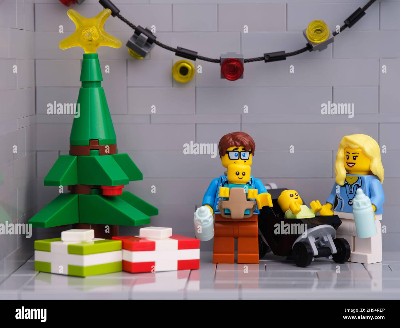 Tambow, Russische Föderation - 01. Dezember 2021 Eine Lego-Familie - Vater und Mutter mit zwei Babys minifiguren, die in der Nähe eines Weihnachtsbaums stehen, der p hat Stockfoto