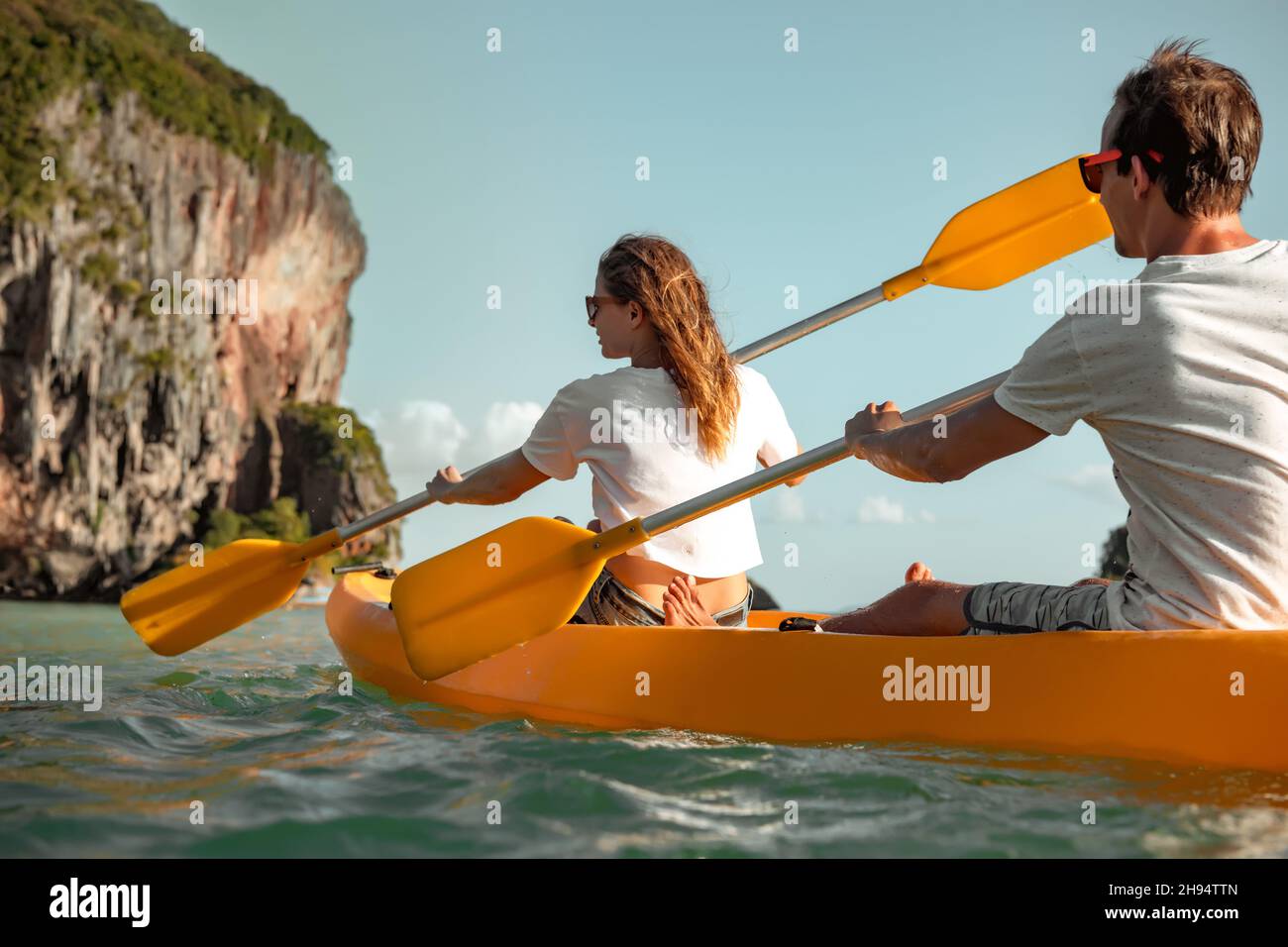 Nahaufnahme eines jungen Paares, das mit dem Kajak oder Kanu unterwegs ist. Kajakfahren oder Kanufahren in der tropischen Bucht Stockfoto