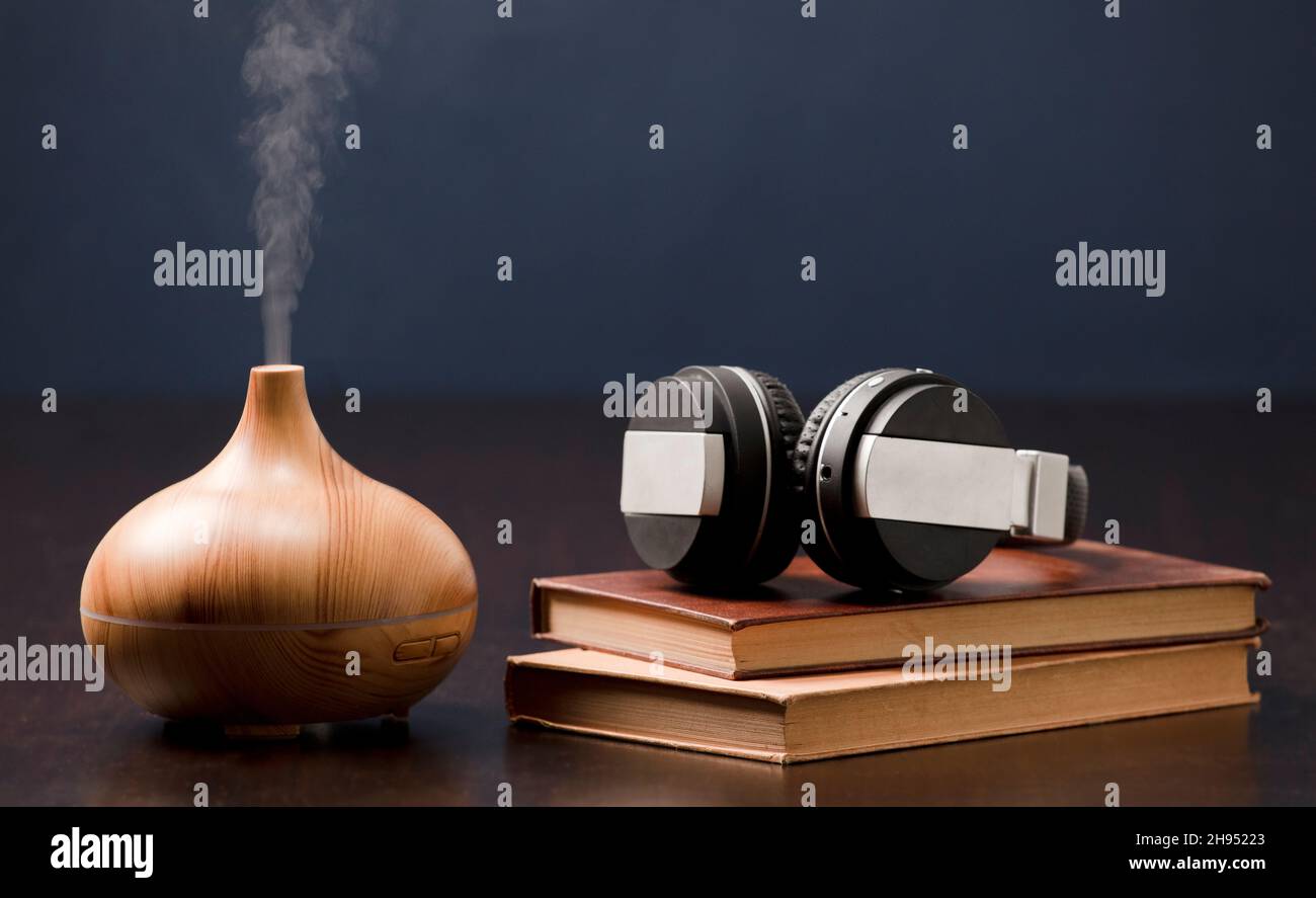 Entspannung zu Hause mit Aromatherapie-Öl-Diffusor und Kopfhörer mit Buch. Aroma Essenz der Gesundheit, Wellness Aromatherapie Home aromatisch ruhig ther Stockfoto