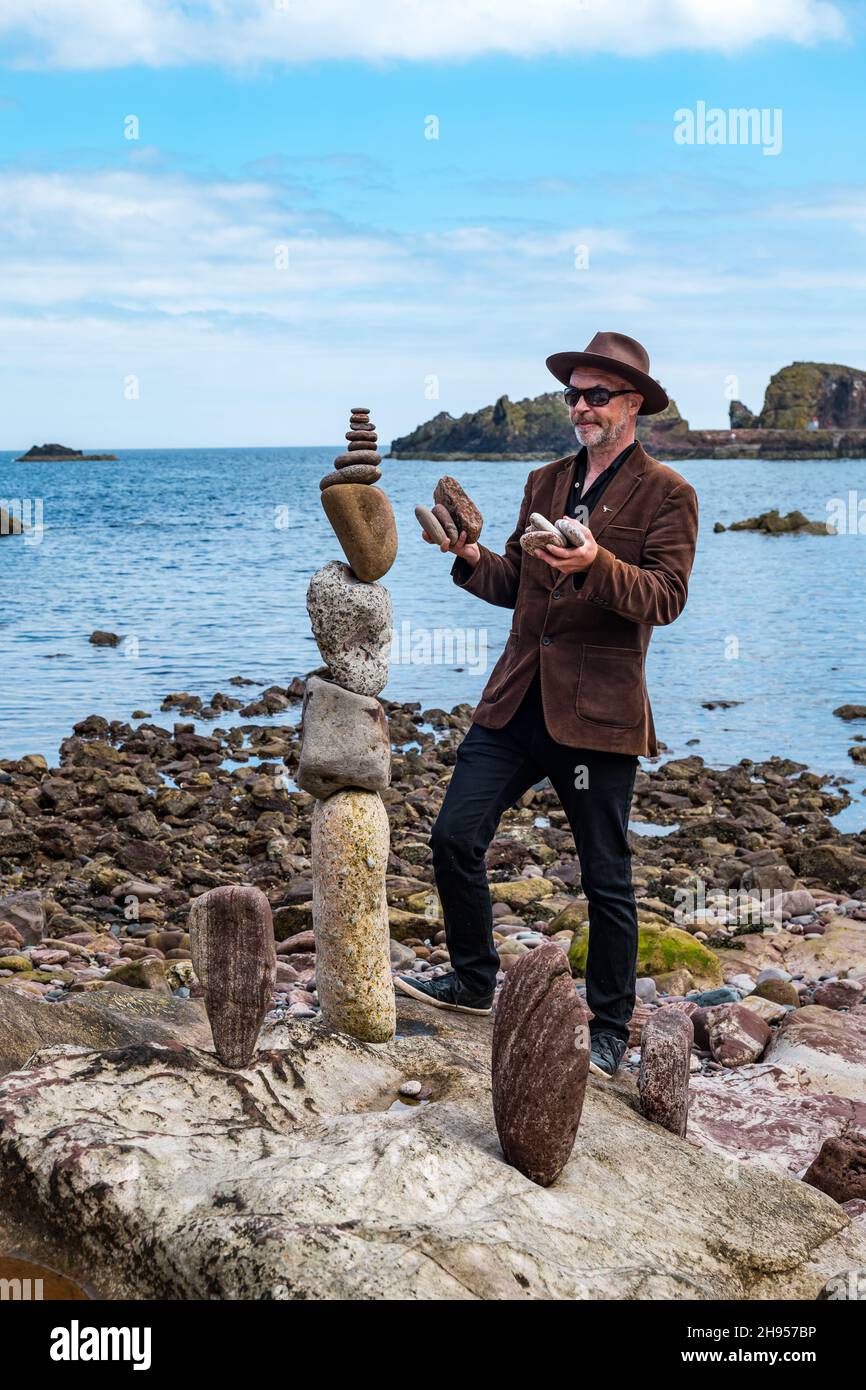 James Craig Page, Stone Stacker und Organisator der European Stone Stacking Championship, kreiert Steinskulpturen, Dunbar, East Lothian, Schottland, Großbritannien Stockfoto