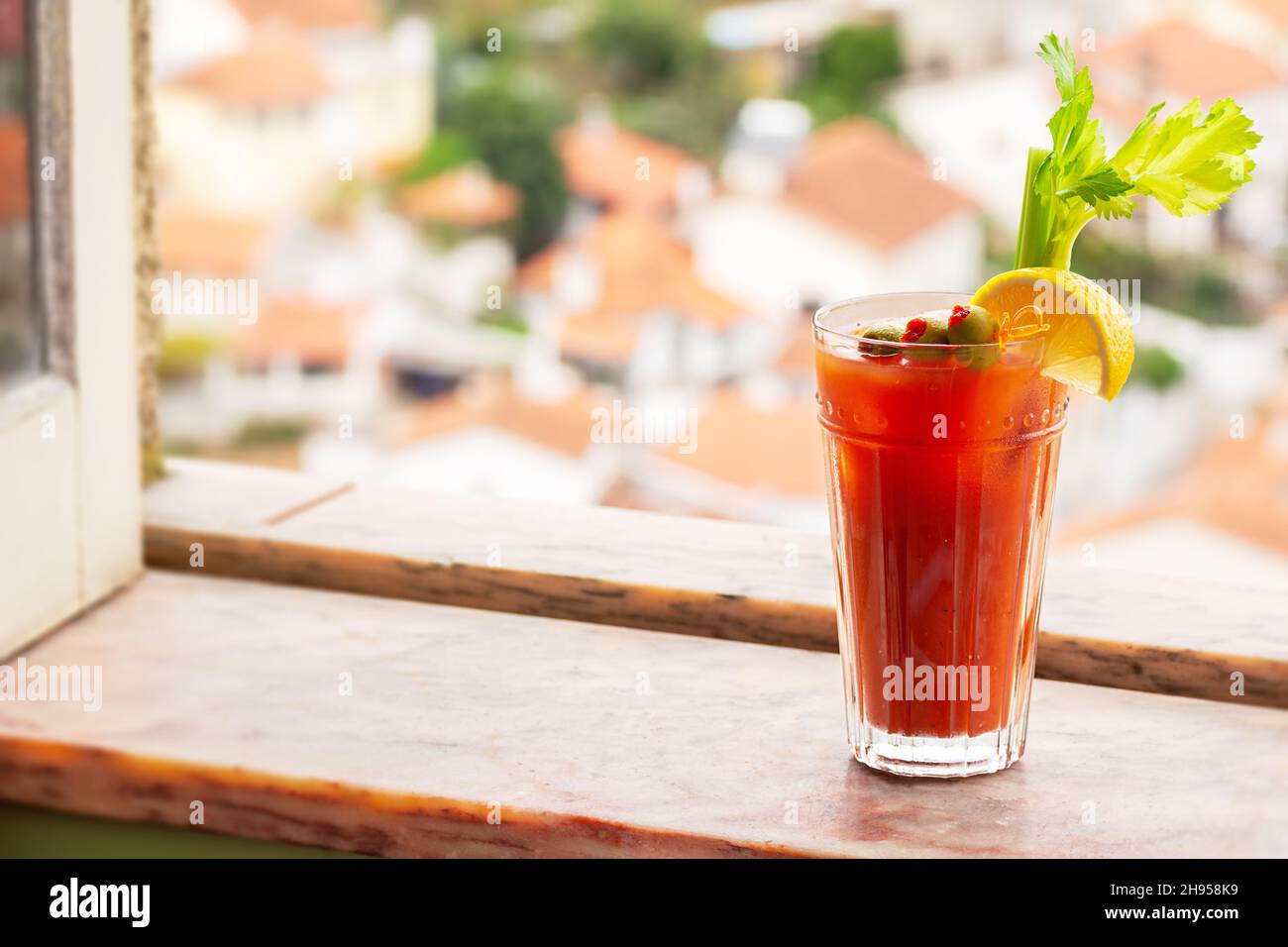 Bloody Mary Cocktail Drink mit Ölkrisen, Zitrone und Sellerie auf Marmorfensterbank im Europäischen Portugiesischen Dorf Stockfoto
