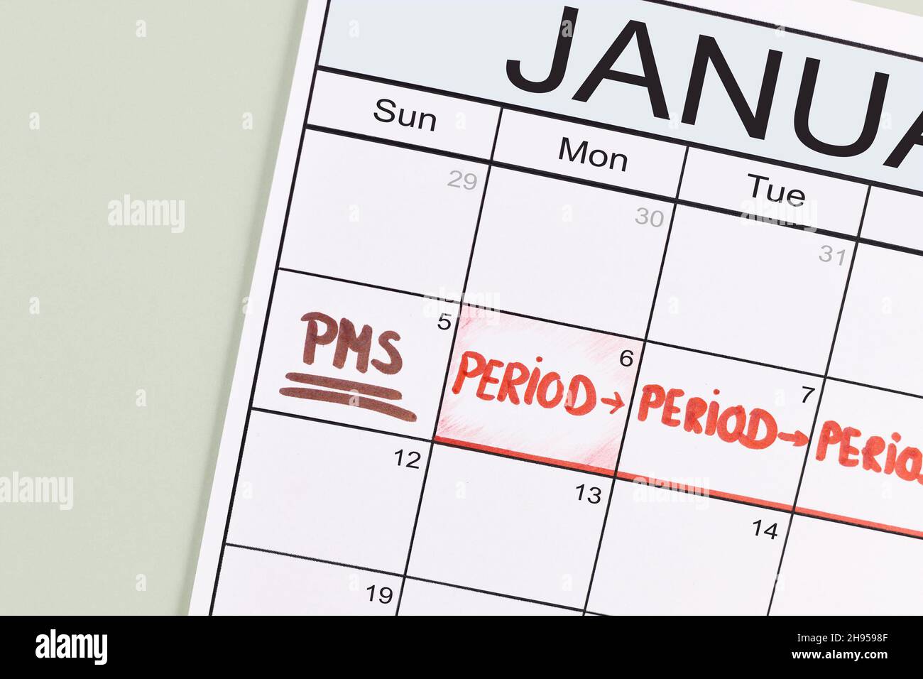 Prämenstruelles Syndrom und Konzept der weiblichen Periode mit Kalenderdatum mit PMS und Periode, die mit roten Wörtern gekennzeichnet ist Stockfoto