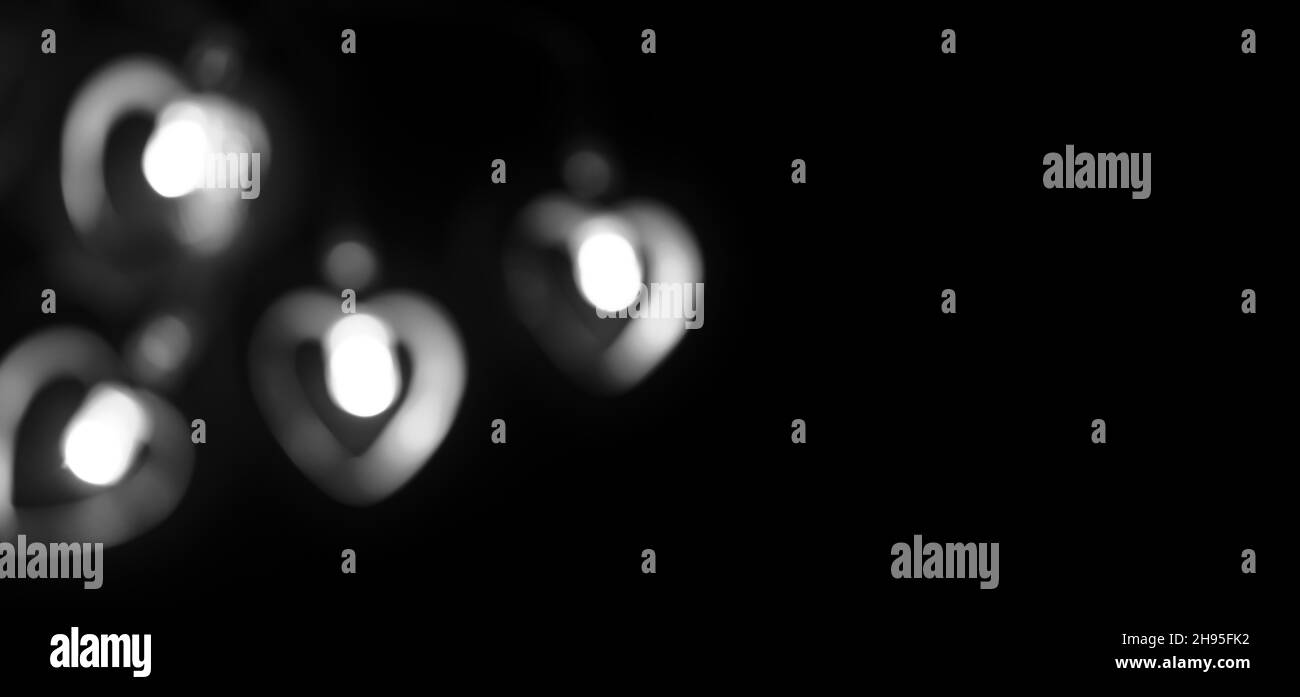 Schwarzes Banner mit Platz für Text. Vier weiße, verschwommene Lichter in Form eines Herzens. Copyspace. Stockfoto