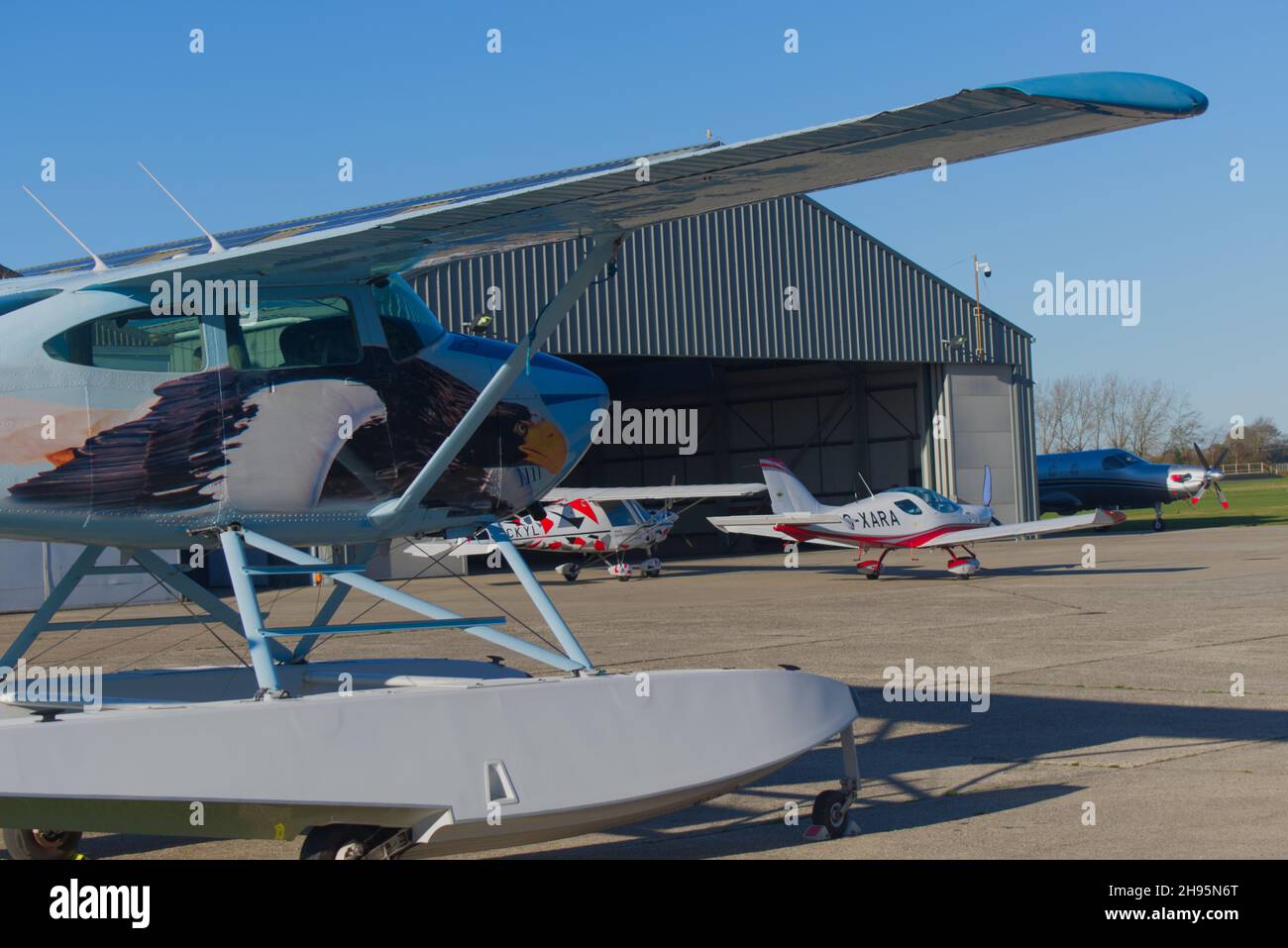 Ein Cessna 182R Skylane Float-Flugzeug registrierte G=ESSL mit einem Entwurf eines Adlers auf dem Rumpf, der auf dem Vorfeld des Goodwood Aerodroms geparkt war. Stockfoto