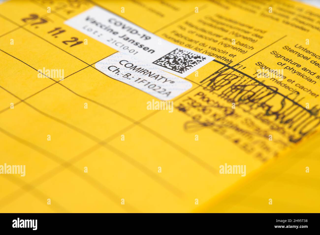 Stuttgart, Deutschland - 04. Dezember 2021: Auffrischungsimpfung gegen das Corona Covid-19-Virus. Gelbe Impfkarte mit Proof-Etikett. Impfstoff von Bi Stockfoto