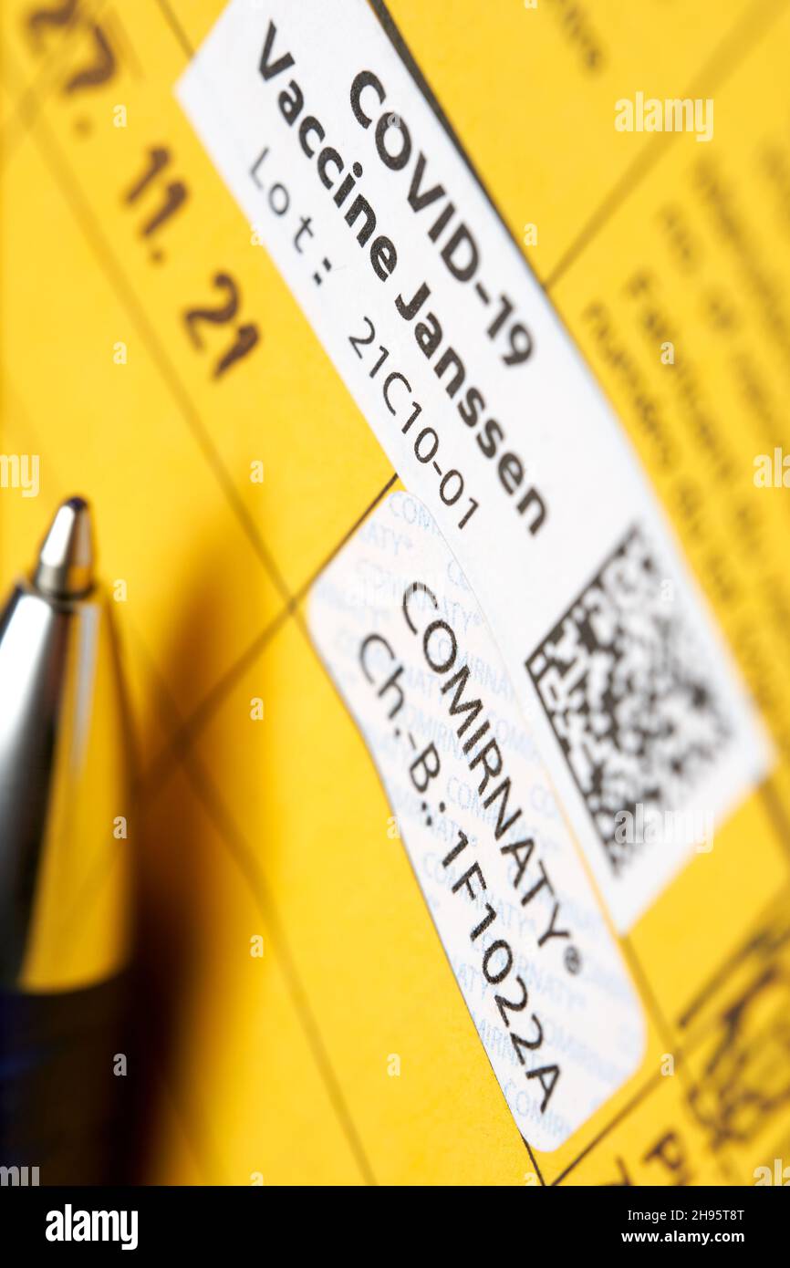 Stuttgart, Deutschland - 04. Dezember 2021: Auffrischungsimpfung gegen das Corona Covid-19-Virus. Gelbe Impfkarte mit Proof-Etikett. Impfstoff von Bi Stockfoto