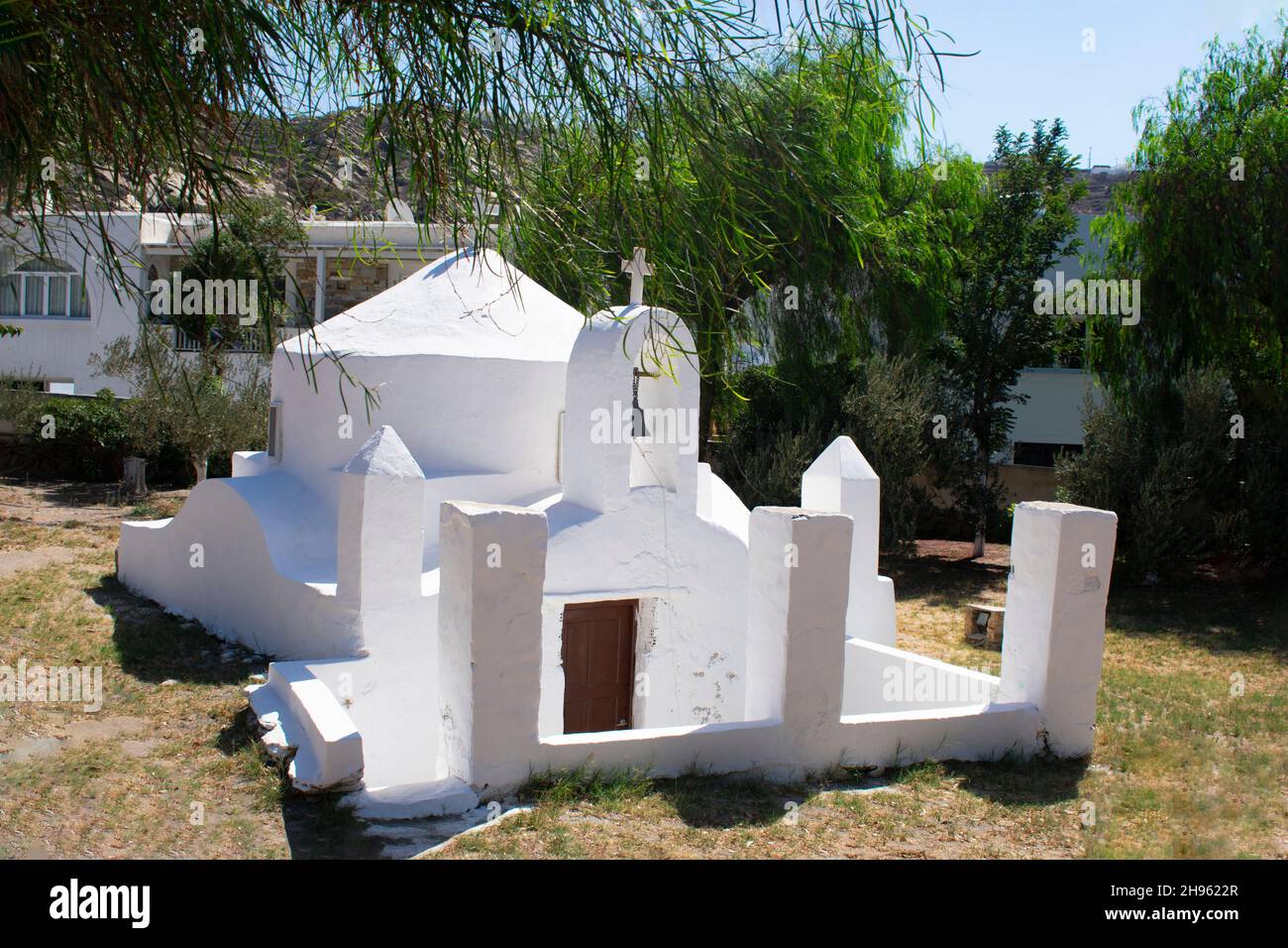 Wunderschöne Ios Insel Griechenland. Charmante kleine Kapelle in einer abgelegenen Waldlichtung. Lokales Wahrzeichen am Hafen der Inseln.Landschaftsansicht. Stockfoto