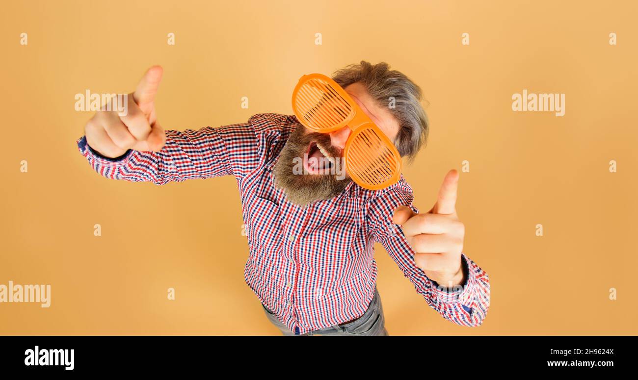 Lustiger bärtiger Mann in einer großen Brille, der die Finger nach oben zeigt. Werbung. Saisonangebot. Rabatt. Speicherplatz kopieren. Stockfoto