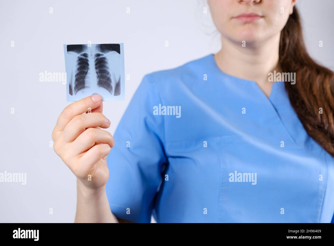 Ein Arzt in blauer Uniform zeigt ein Bild eines Fluorogramms der Fluorographie, eine Röntgenaufnahme der Lunge zur Prävention und Früherkennung Stockfoto